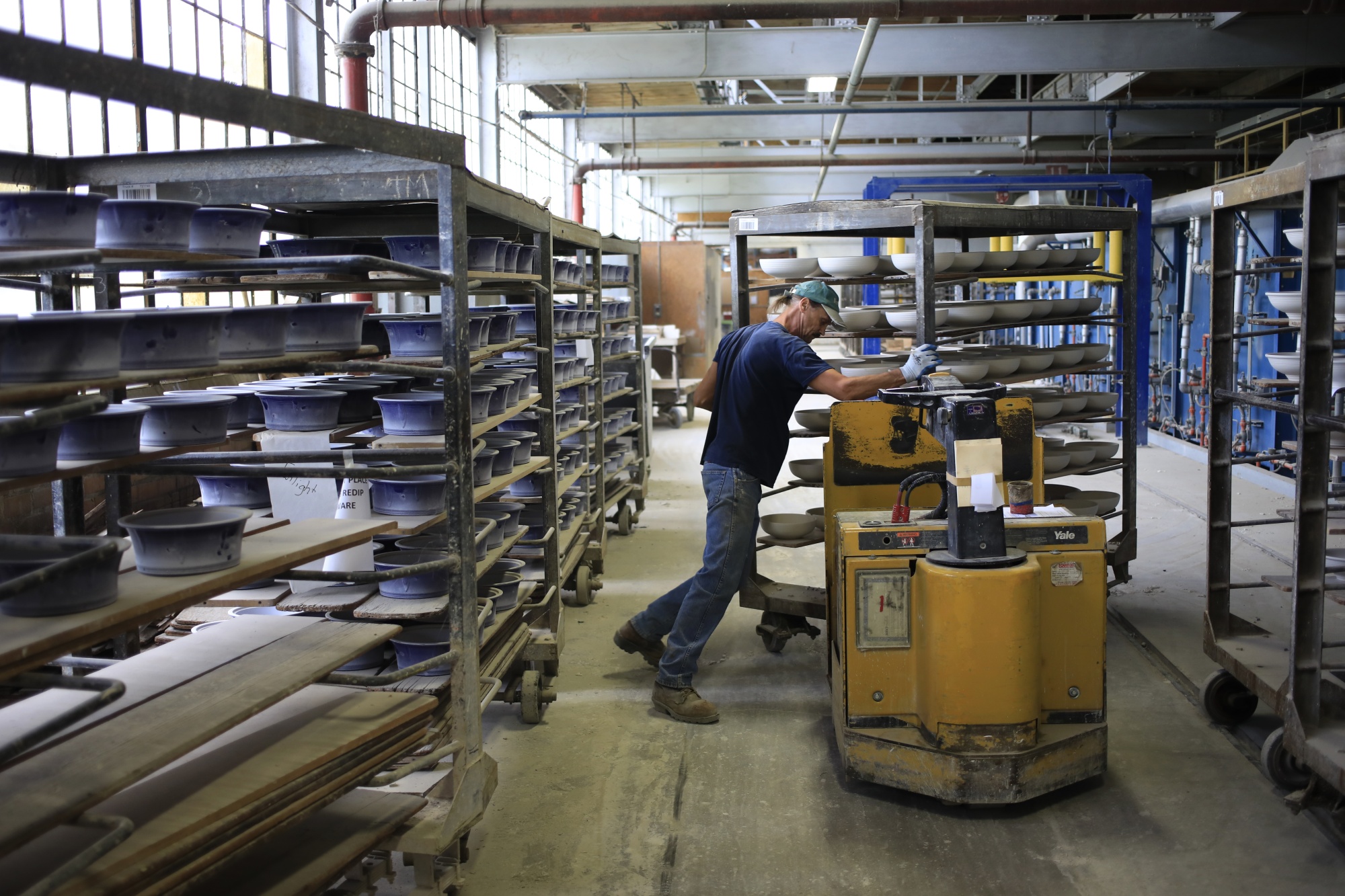 A worker loads carts of dinnerware at a&nbsp;factory in West Virginia.&nbsp;