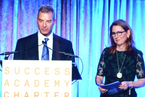 Dan Loeb and Eva Moskowitz as seen on a screen near the cheap seats