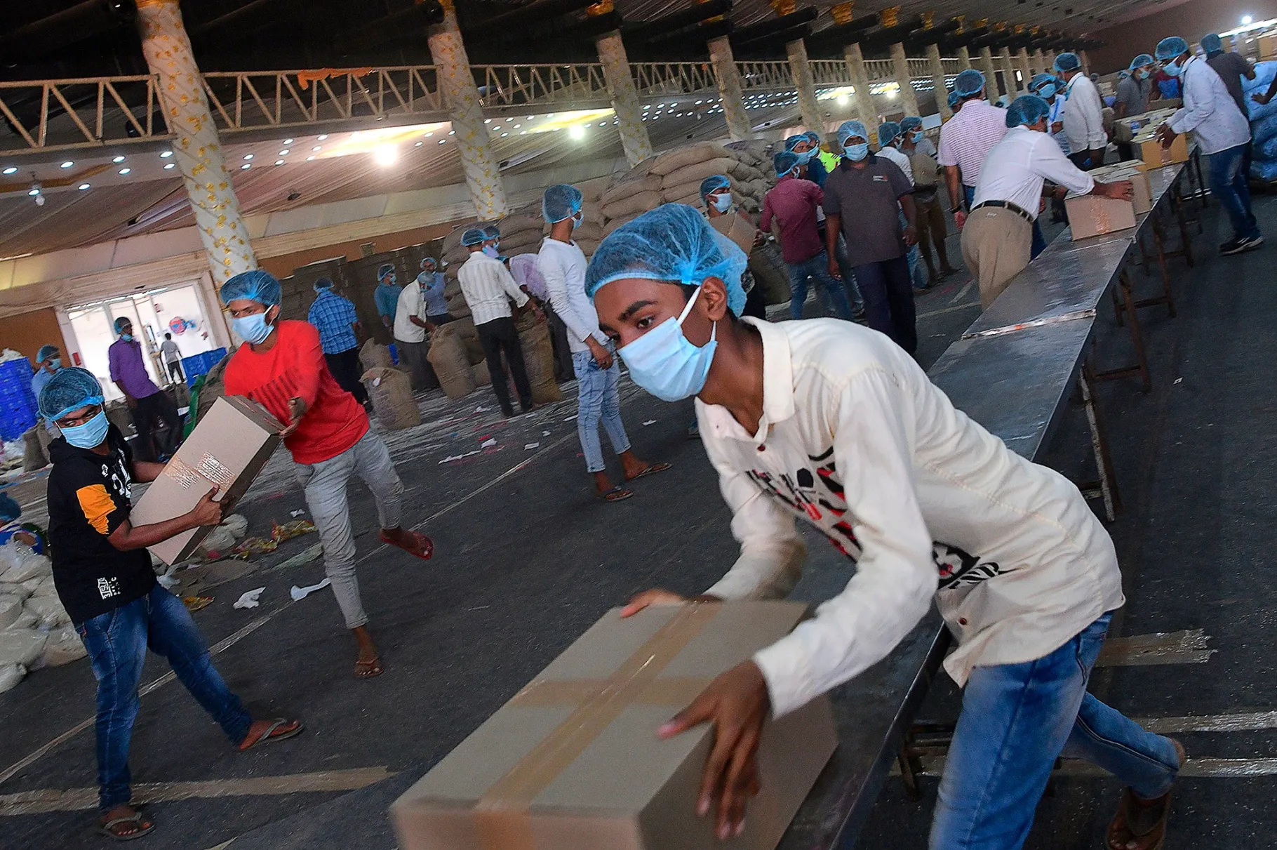 Jobless labourers load trucks with&nbsp;emergency essentials and groceries for distribution in Bangalore, India.