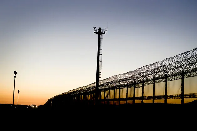 A vehicle drives alongside part of the U.S.-Mexico border fence in San Diego, California