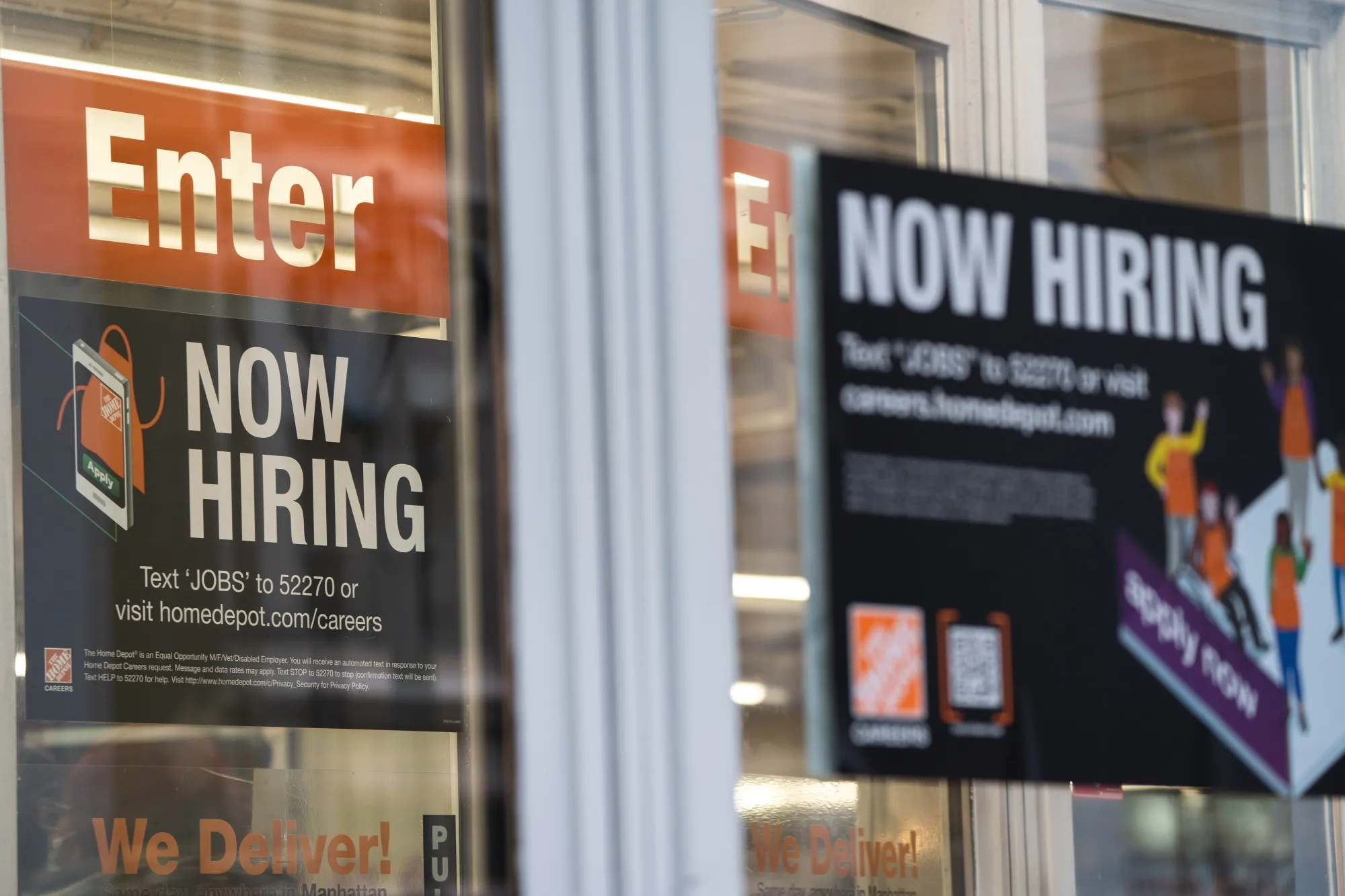 A "Now Hiring" sign outside a Home Depot store in New York.