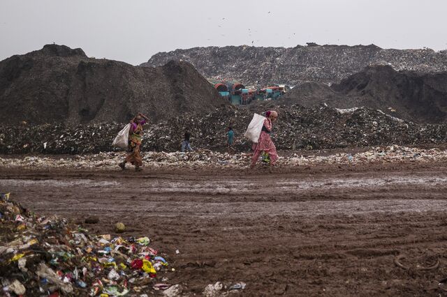 Salvagers collect materials for recycling at Ghazipur. Trommel machines used to separate waste are visible in the background.