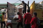 Workers offload sacks of rice from a truck at a market in Jakarta, Indonesia.