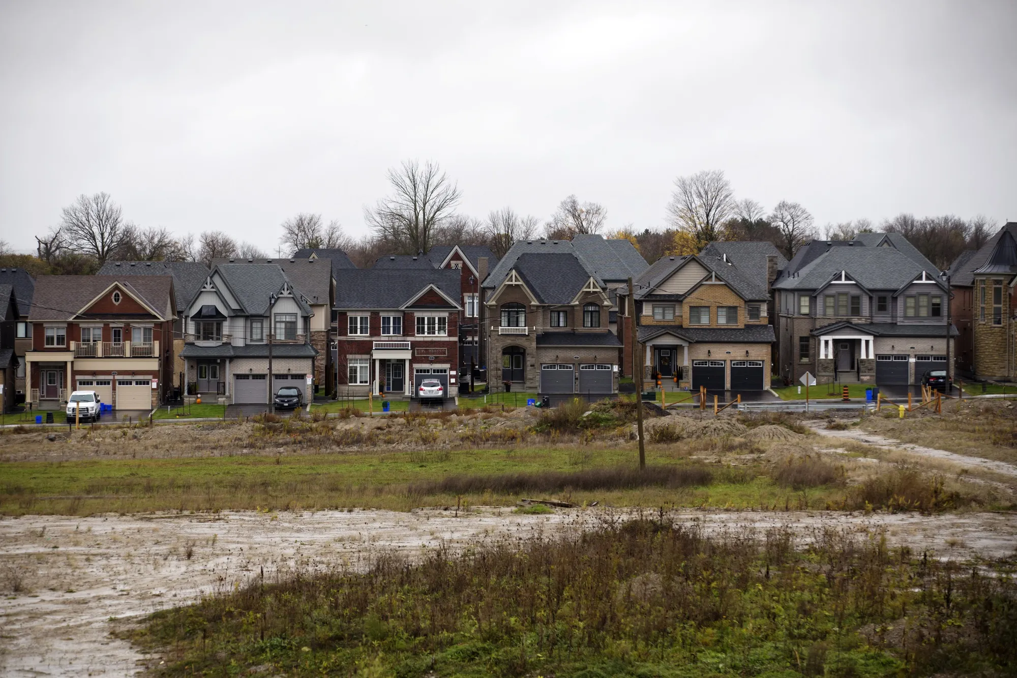 Homes stand beyond an undeveloped plot of land in East Gwillimbury, Ontario.