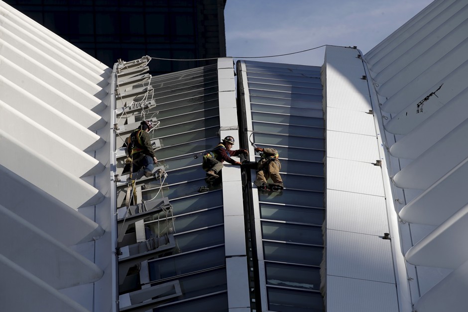 Men work on a portion of the retractable roof of the Oculus structure of the World Trade Center Transportation Hub in Manhattan, March 1, 2016.