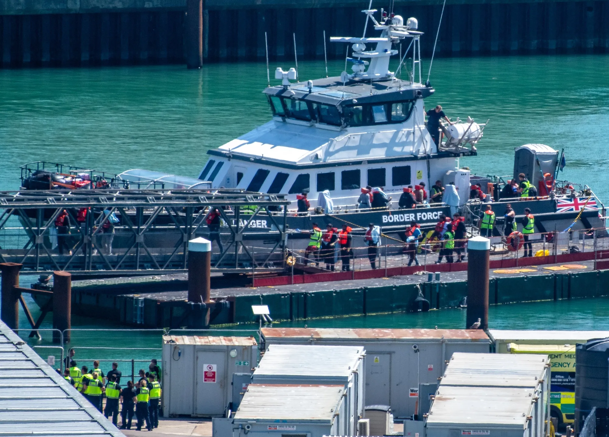 Migrants disembark from a British Border Force vessel after being picked up in the English Channel last August.