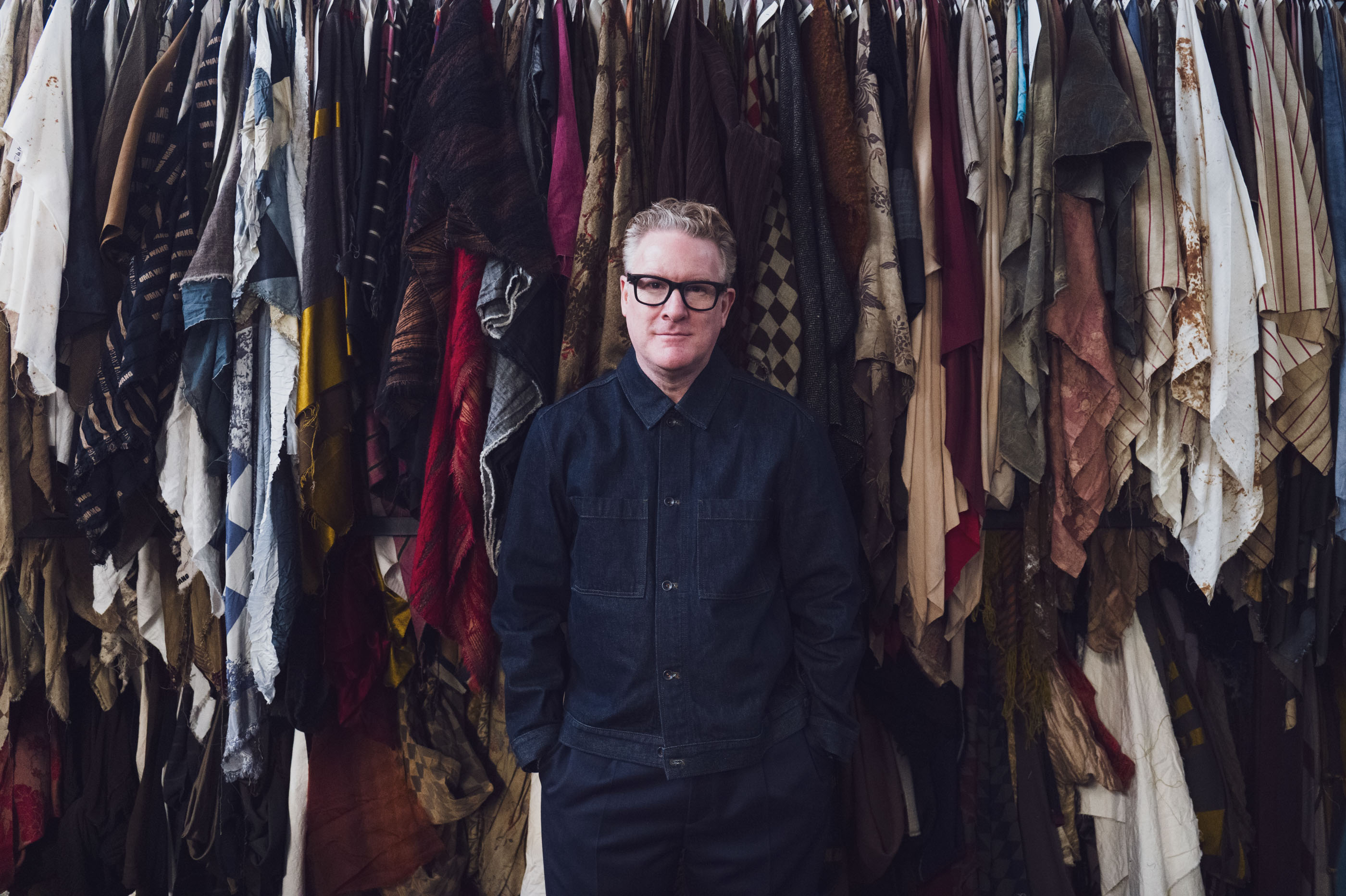 Snyder in front of archive fabrics at the Lyria mill in Tuscany. 
