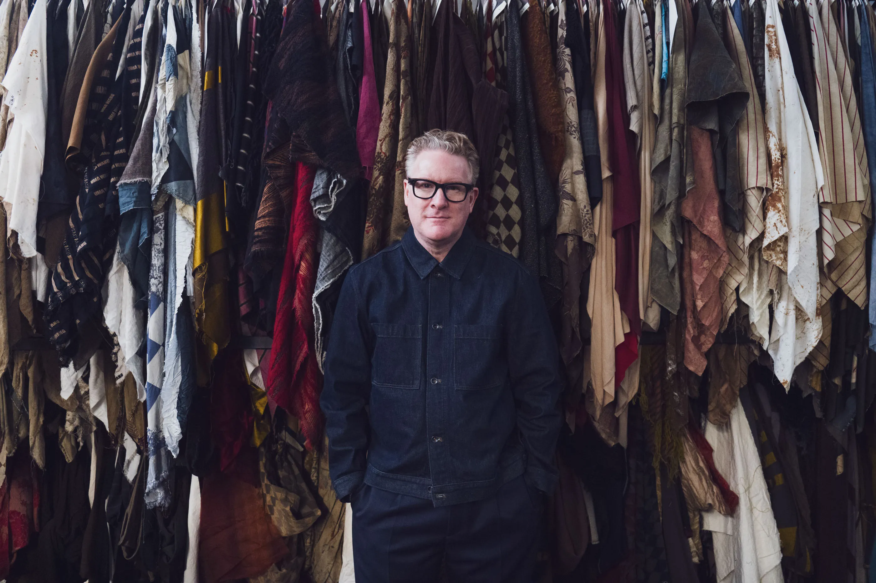 Snyder in front of archive fabrics at the Lyria mill in Tuscany.&nbsp;