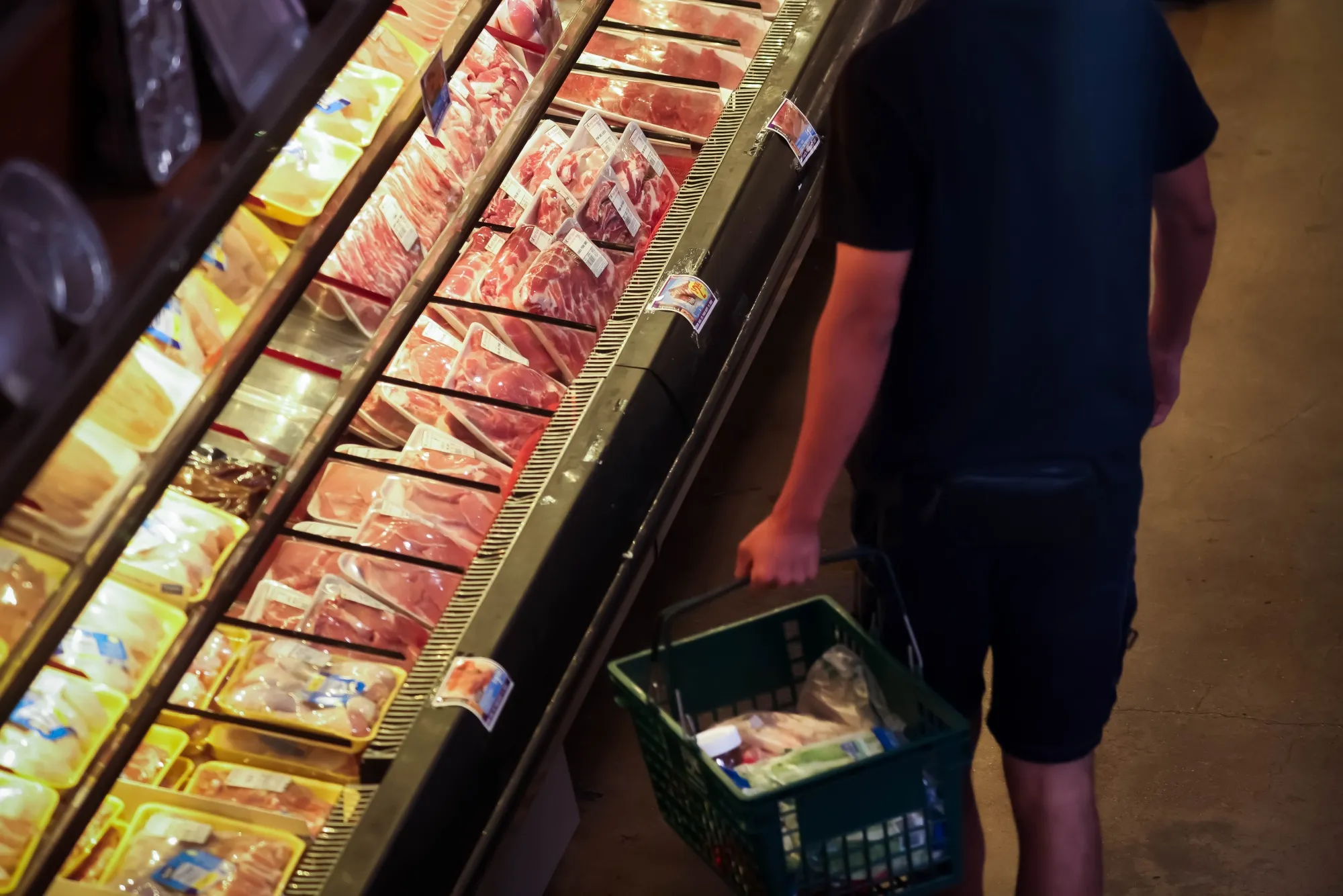 A shopper browses meat at a grocery store in New York.
