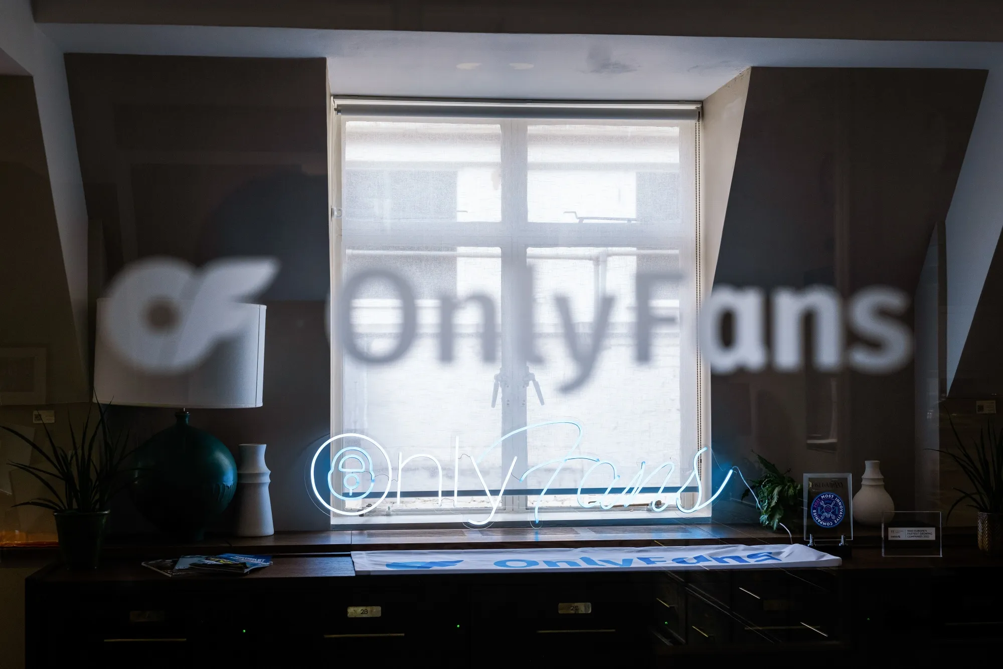 A neon OnlyFans sign in the window of the company's offices in London