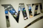 Traders working on the Mizuho Americas trading floor are reflected in a mirror.