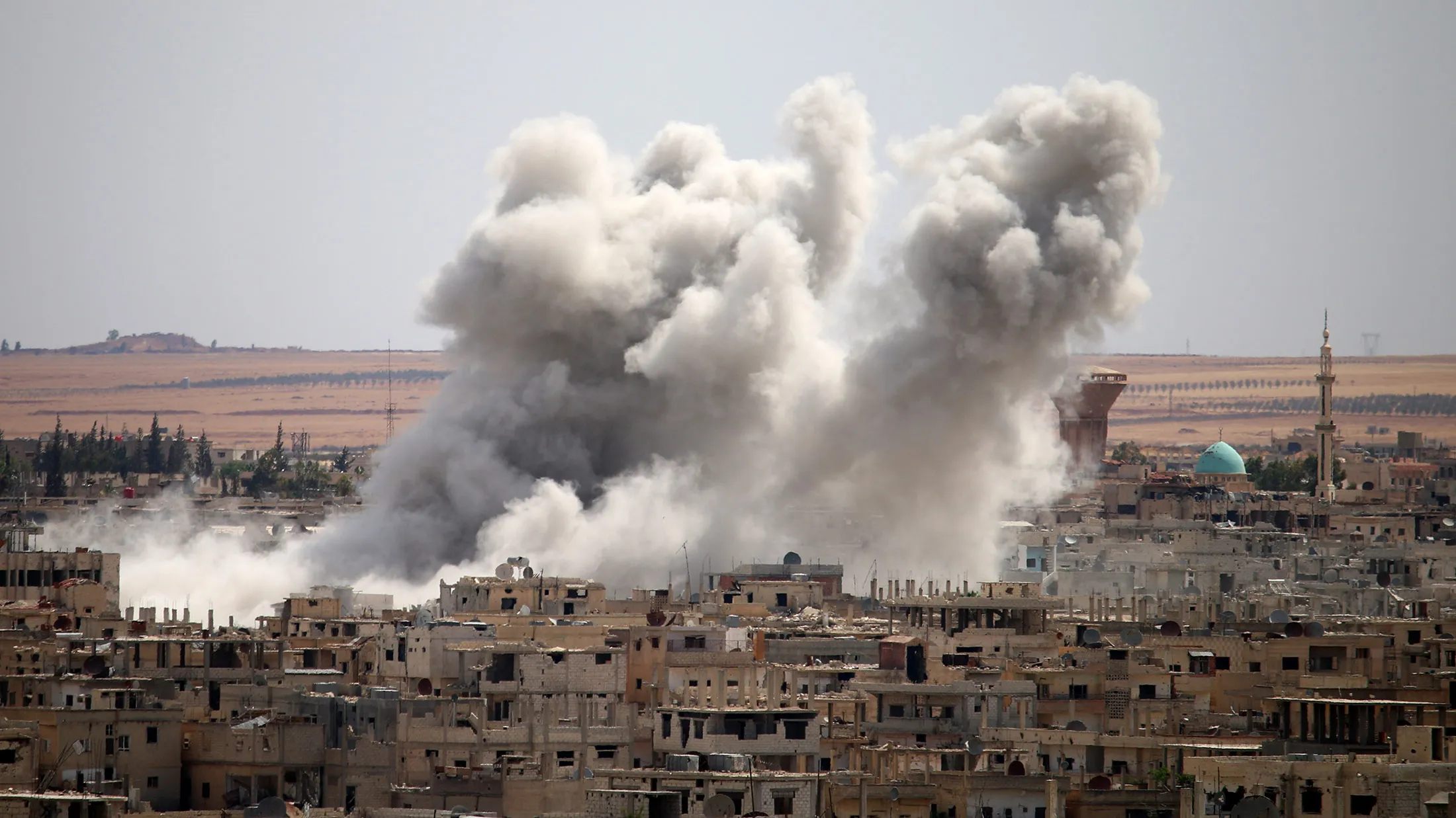 Smoke rises from buildings following a reported air strike on a rebel-held area in the southern Syrian city of Daraa, on June 14, 2017. / AFP PHOTO / Mohamad ABAZEED (Photo credit should read MOHAMAD ABAZEED/AFP/Getty Images)
