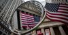 An American flag displayed outside of the New York Stock Exchange (NYSE) is reflected in a mirror in New York, U.S., on Tuesday, Sept. 6, 2016. Warnings embedded in strategist price targets and historically low U.S. stock volatility are doing nothing to dissuade hedge funds.