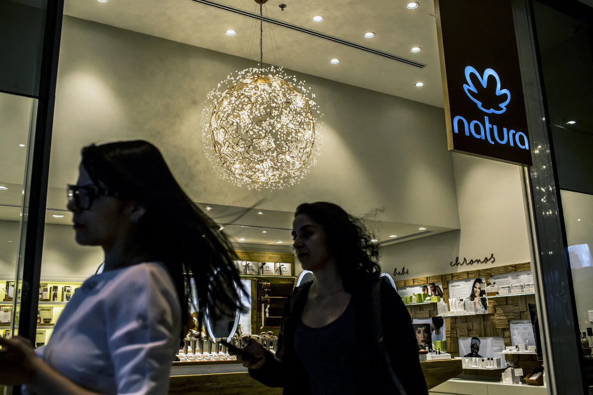 People pass a Natura Cosmeticos store in Rio de Janeiro.