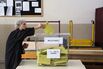 An elderly voter places her vote slip into a ballot box at a polling station in the Turkish general election in Istanbul, Turkey, on Sunday, June 7, 2015.
