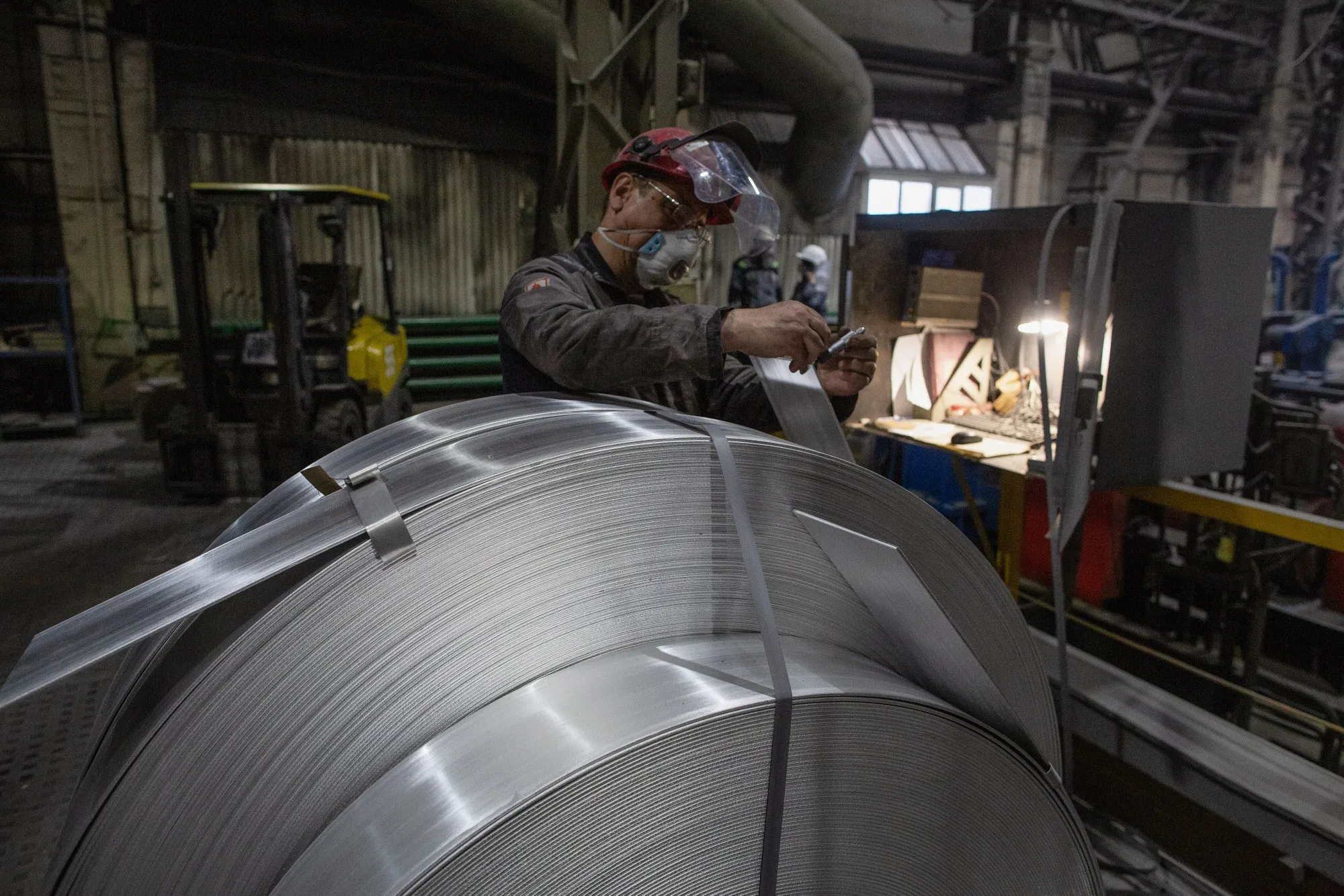 A worker labels rolls of sheet aluminium at the United Co. Rusal aluminium smelting plant in Shelekhov, Russia.