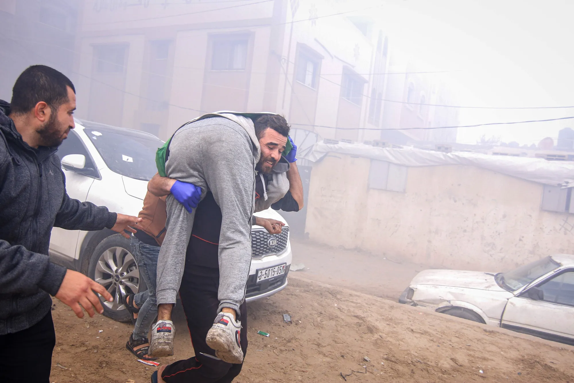 A man carries an injured Palestinian away from the site of an Israeli airstrike in Khan Younis, southern Gaza, on Thursday, Jan. 11, 2024.&nbsp;