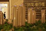 A guard stands near models of East No. 1, a Shimao Group residential development in Kunshan, China, on Saturday, March 20, 2009.