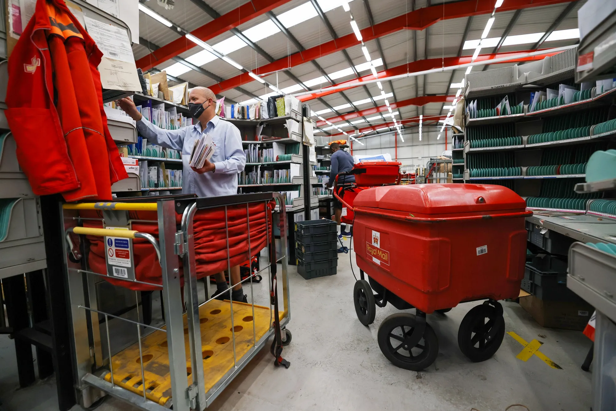 An employee sorts items of post at the Royal Mail Plc sorting office in Chelmsford, UK.