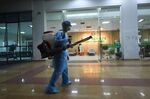 A medical worker sprays antiseptic outside an isolation area at National Hospital of Tropical Diseases in Hanoi.