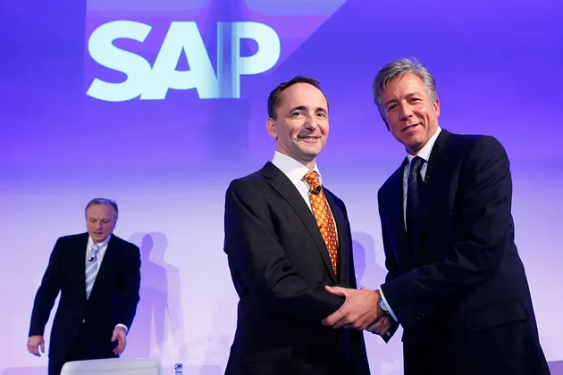 SAP Co-CEOs Jim Hagemann Snabe (center) and Bill McDermott pose for a photograph as CFO Werner Brandt takes his seat at a news conference in Walldorf, Germany, on Jan. 23