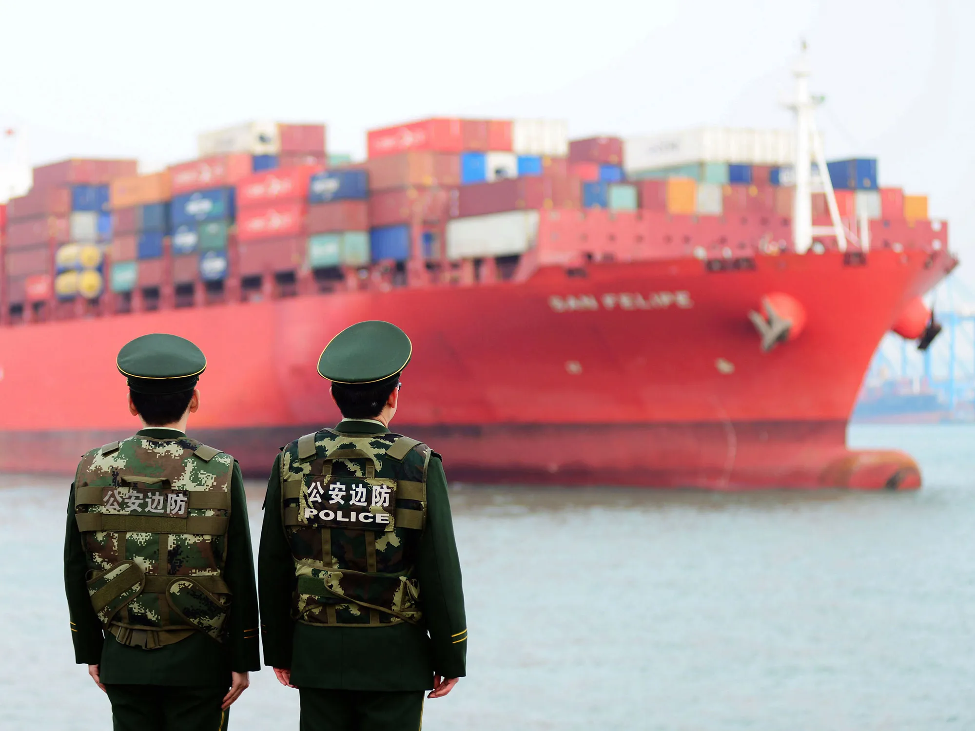 Chinese police officers watch a cargo ship at a port in Qingdao in China's eastern Shandong province.