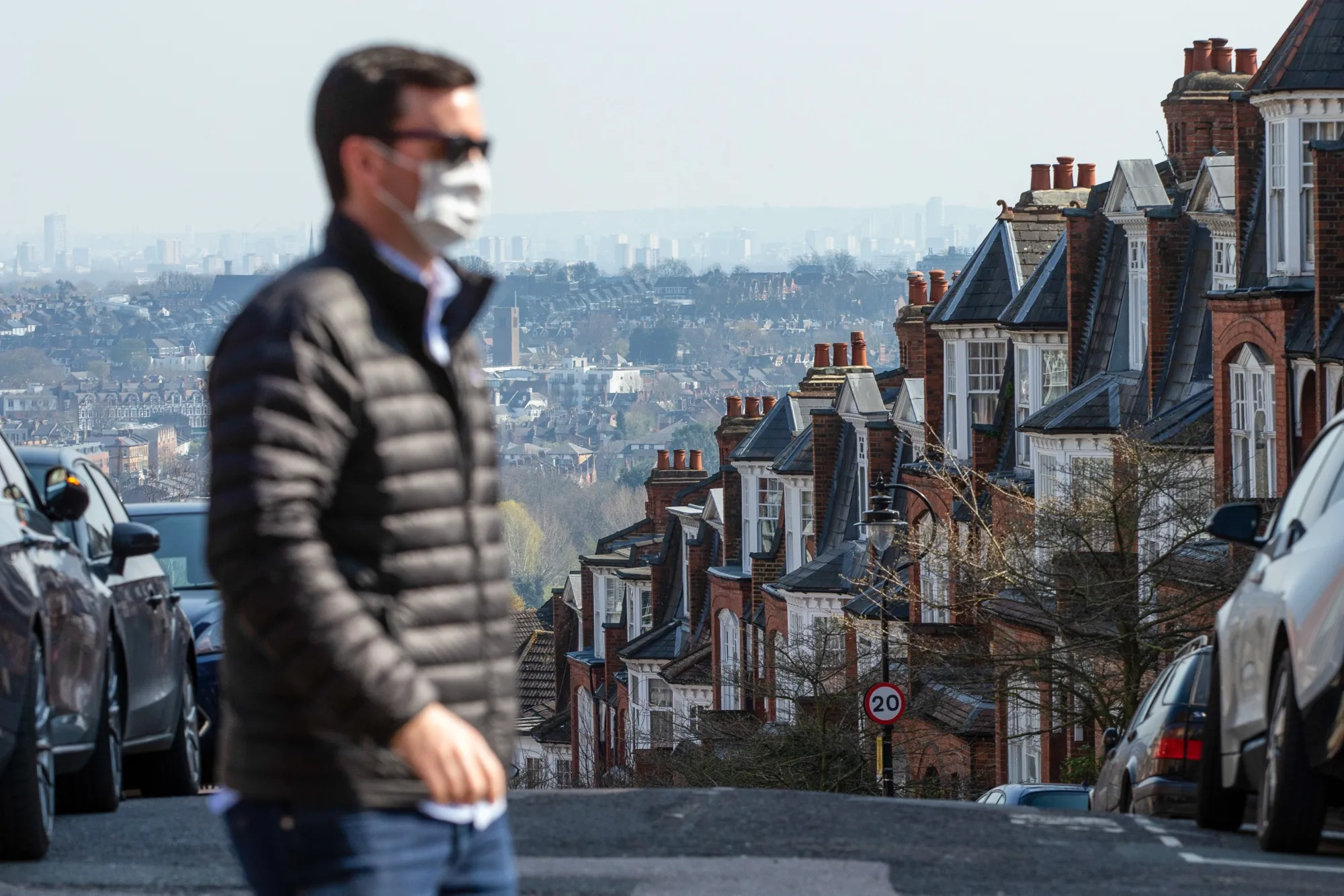 A pedestrian walks past residential properties in London.