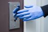 Closeup male hand in medical gloves is pressing elevator call button. 