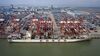 A China Ocean Shipping Group Co. (COSCO) container ship sits moored next to gantry cranes at the Port of Nansha, operated by Guangzhou Port Group Co., in this aerial photograph taken in the Nansha district of Guangzhou, China, on Thursday, April 11, 2019. The U.S. is open to facing "repercussions" if it doesn't live up to its commitments in a potential trade deal with China, U.S. Treasury Secretary Steven Mnuchin said, in a sign that the two sides are edging closer to an accord.