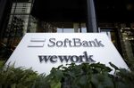 Signage for SoftBank Corp. and WeWork Companies Inc. outside the Tokyo Portcity Takeshiba building, which houses SoftBank Group's headquarters, in Tokyo, Japan, on Friday, Feb. 5, 2021. 