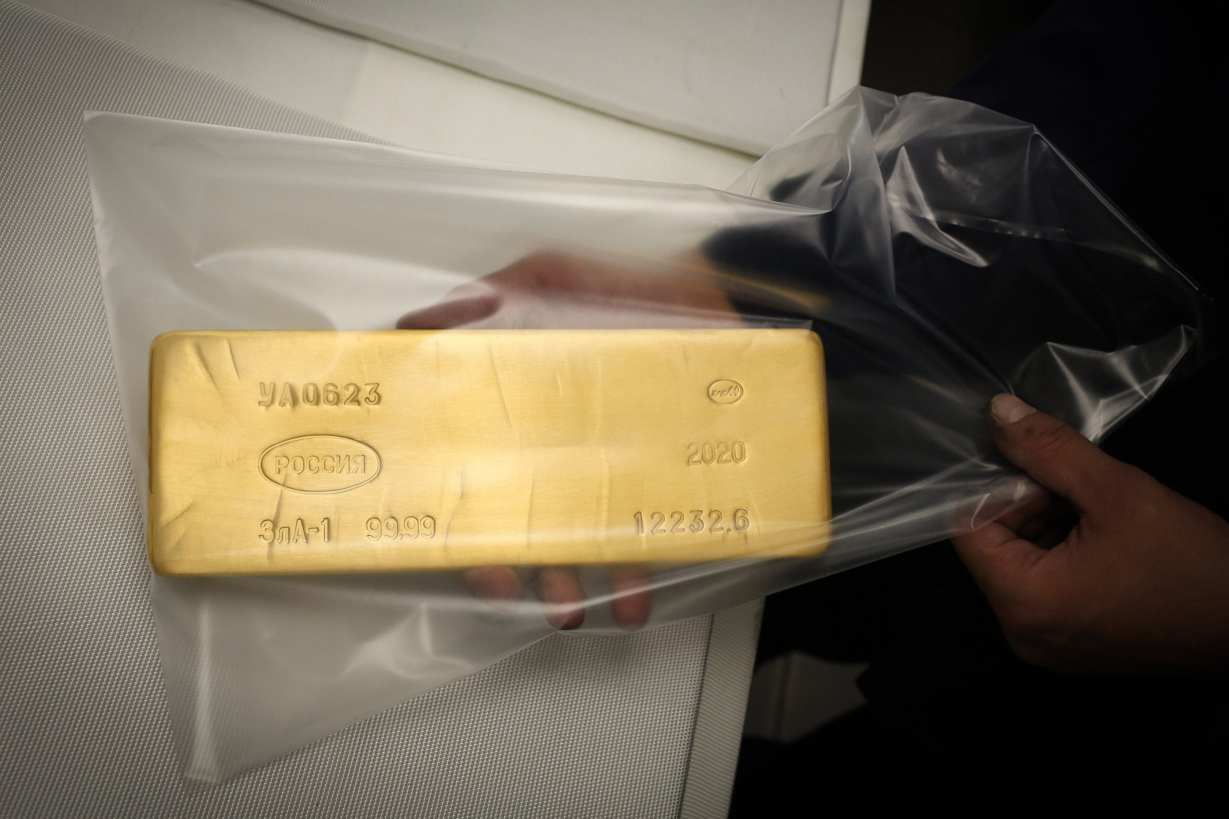 A worker seals a 12.5 kilogram gold ingot into a protective packet at the Uralelectromed Copper Refinery, operated by Ural Mining and Metallurgical Co. (UMMC), in Verkhnyaya Pyshma, Russia, on Thursday, July 30, 2020. Gold surged to a fresh record Friday fueled by a weaker dollar and low interest rates. Silver headed for its best month since 1979.