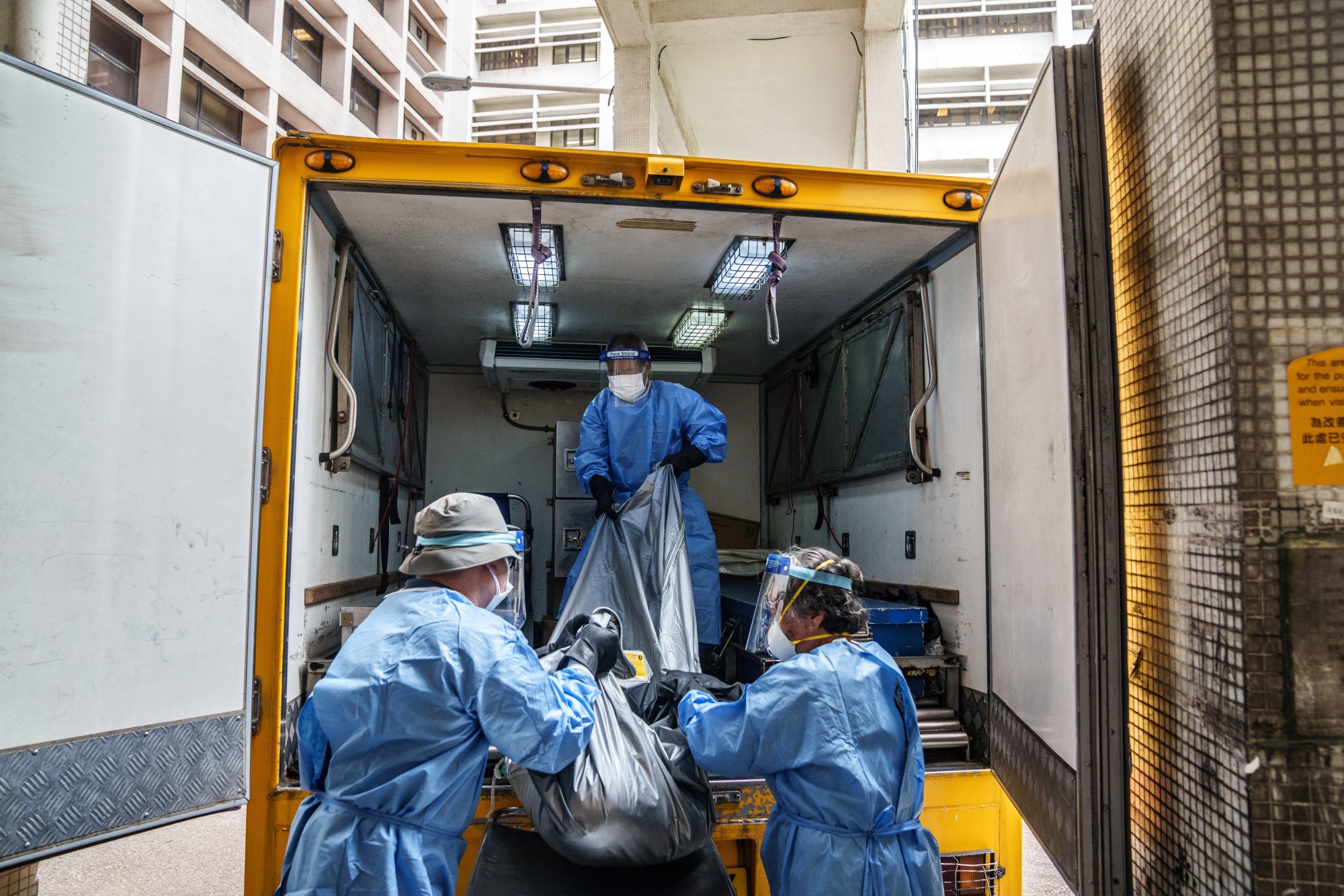 Healthcare workers move the body of a deceased patient at the Queen Elizabeth Hospital on March 2.