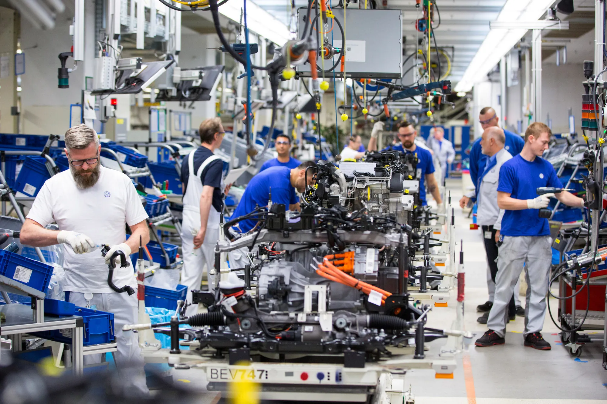 Employees work on the Volkswagen e-Golf electric automobile assembly line inside the Volkswagen factory in Wolfsburg.
