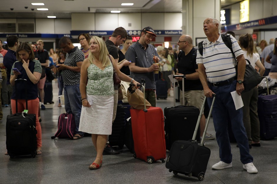Travelers inspect the departures board at Penn Station on in July 2015.