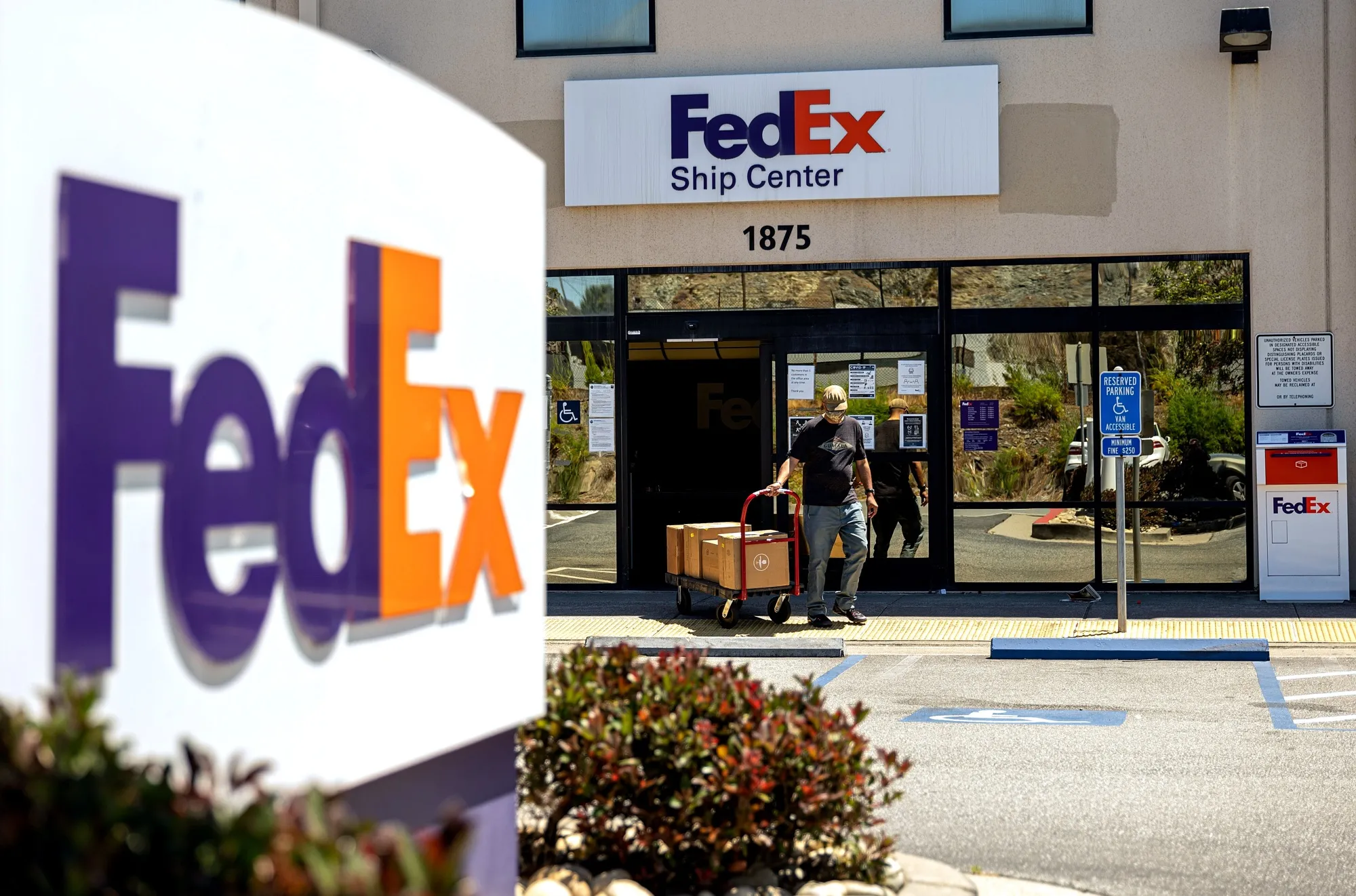 A customer exits a FedEx ship center in San Francisco, California. FedEx earnings missed estimates and the company cut its annual forecast.
