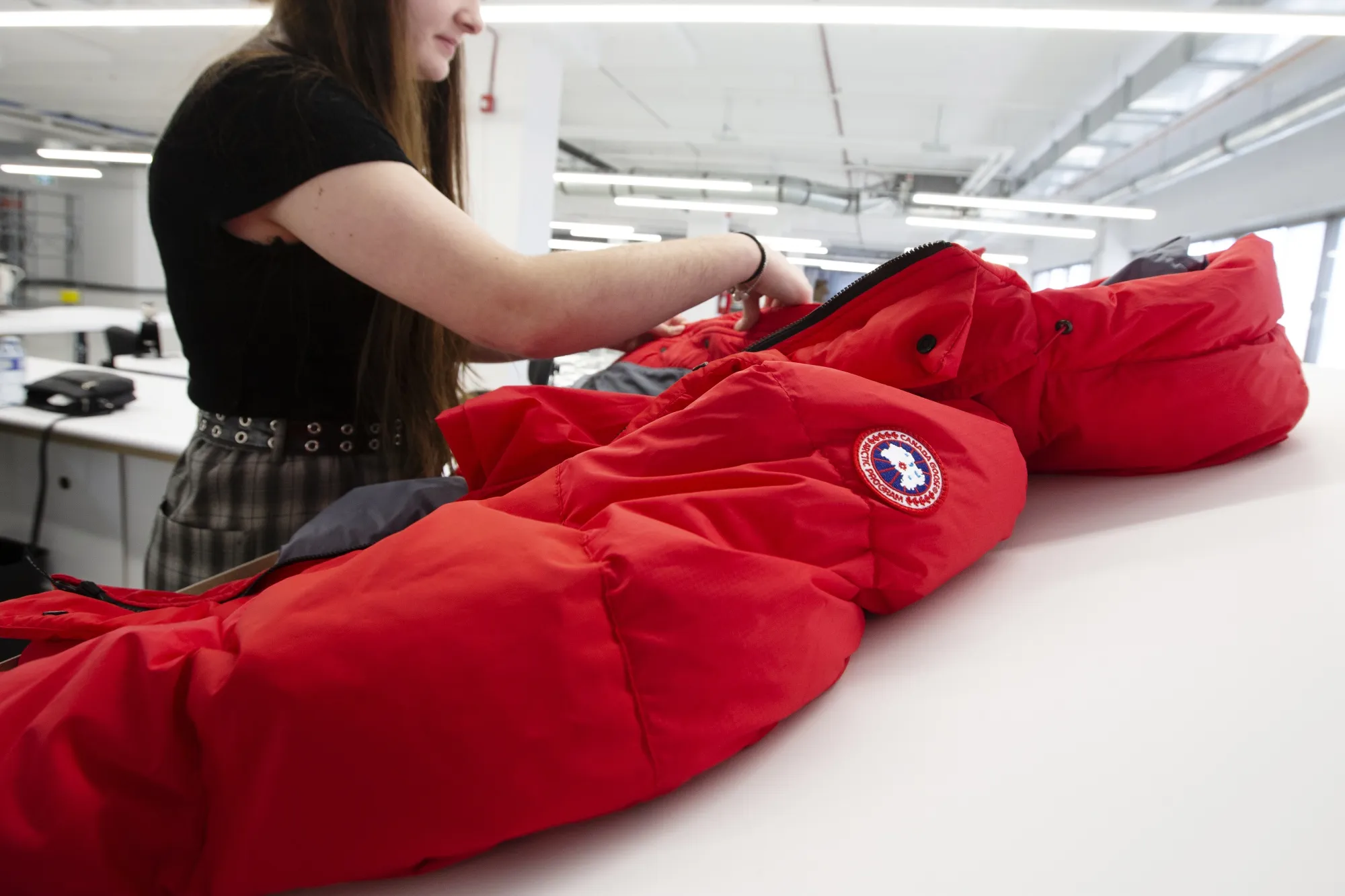 An employee checks a finished jacket at a Canada Goose Inc. manufacturing facility in Montreal, Quebec, Canada in 2019.