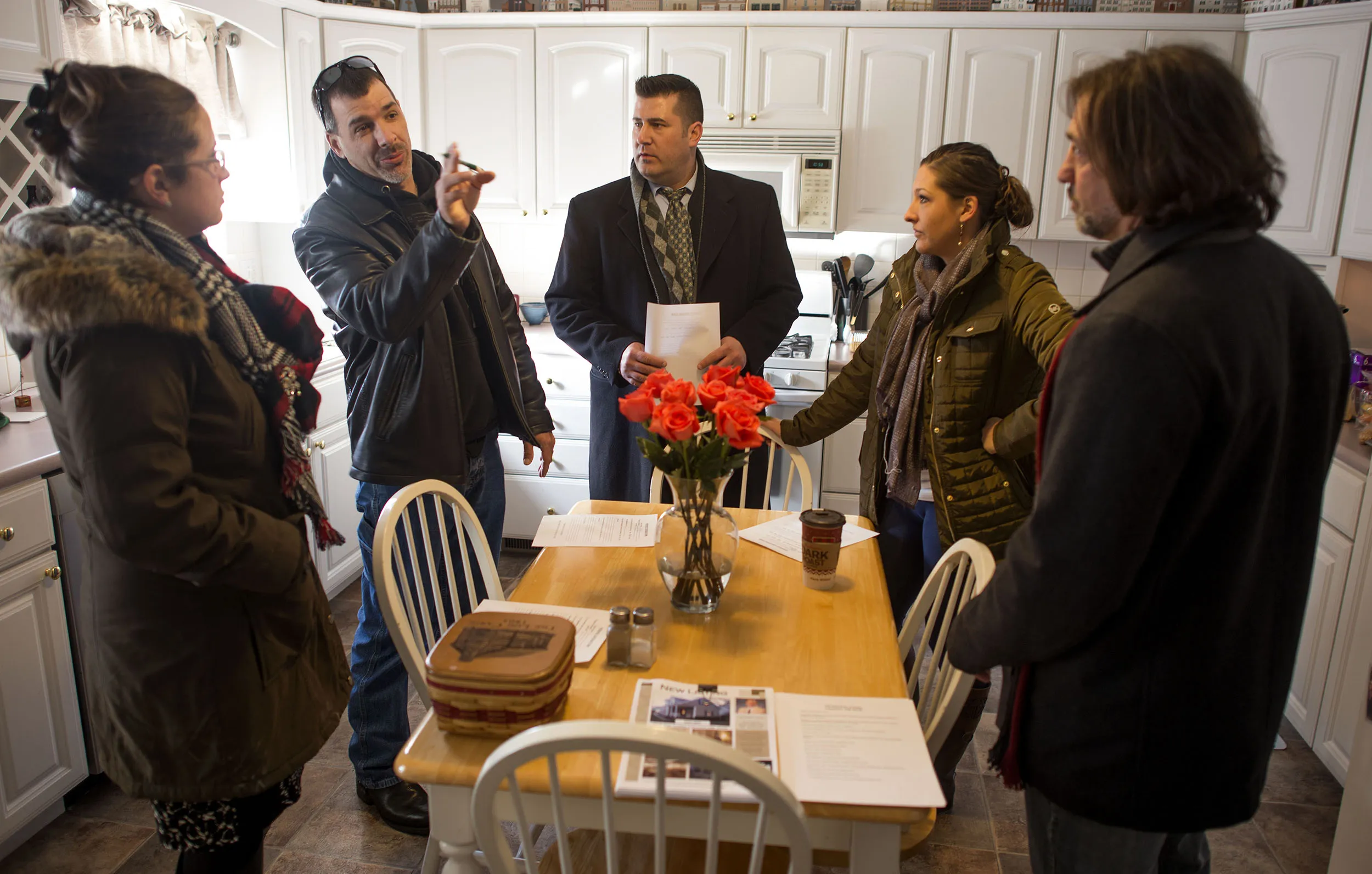 A group of real estate agents and mortgage brokers discuss the condition of a home for sale in Lancaster, Ohio, on, Jan. 9, 2015.
