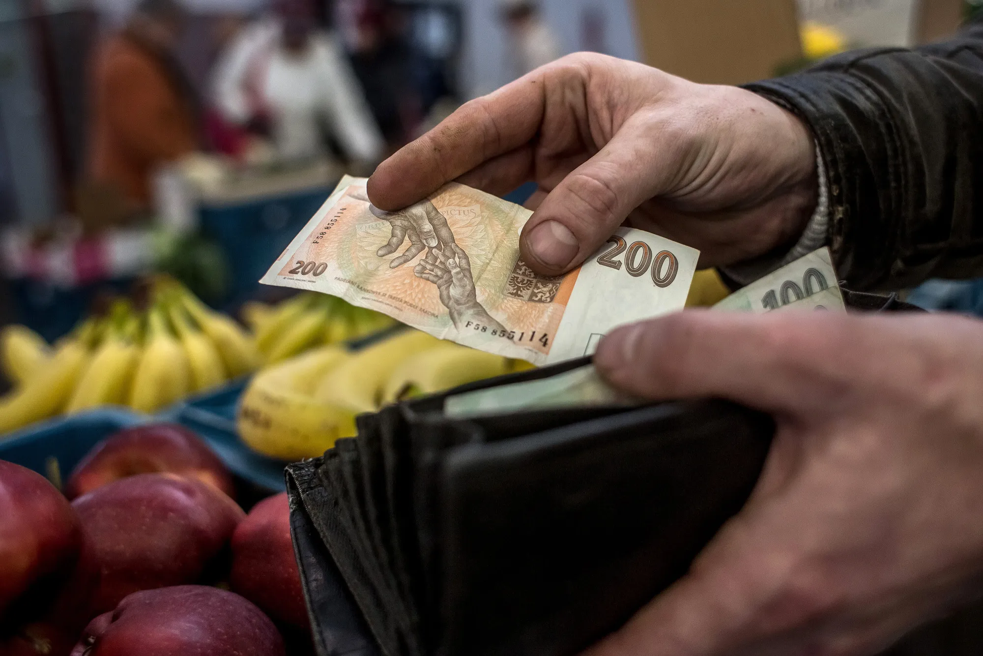 A vendor holds a 200 Czech koruna banknote&nbsp;in Prague.