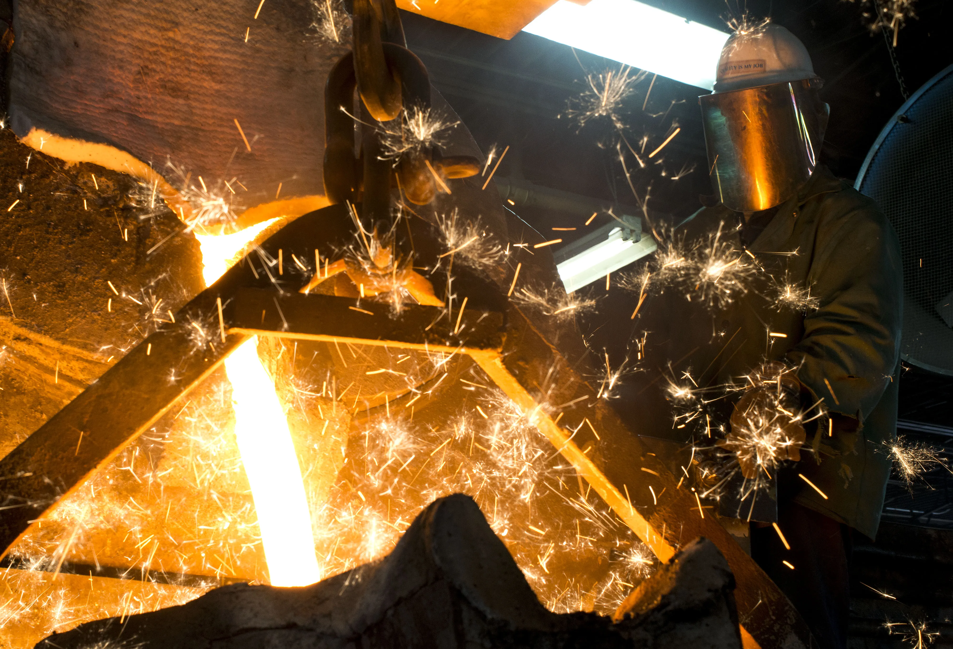 Sparks form as molten iron is poured into a bucket at Trumbull Metal Specialties in Niles, Ohio, U.S., on Friday, April 3, 2015.
