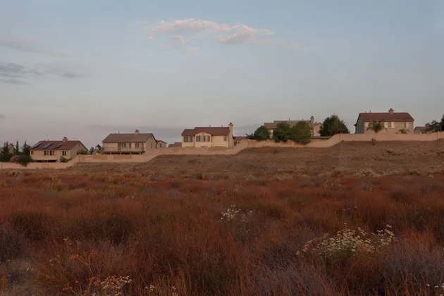A wall separates houses in Murrieta from the desert