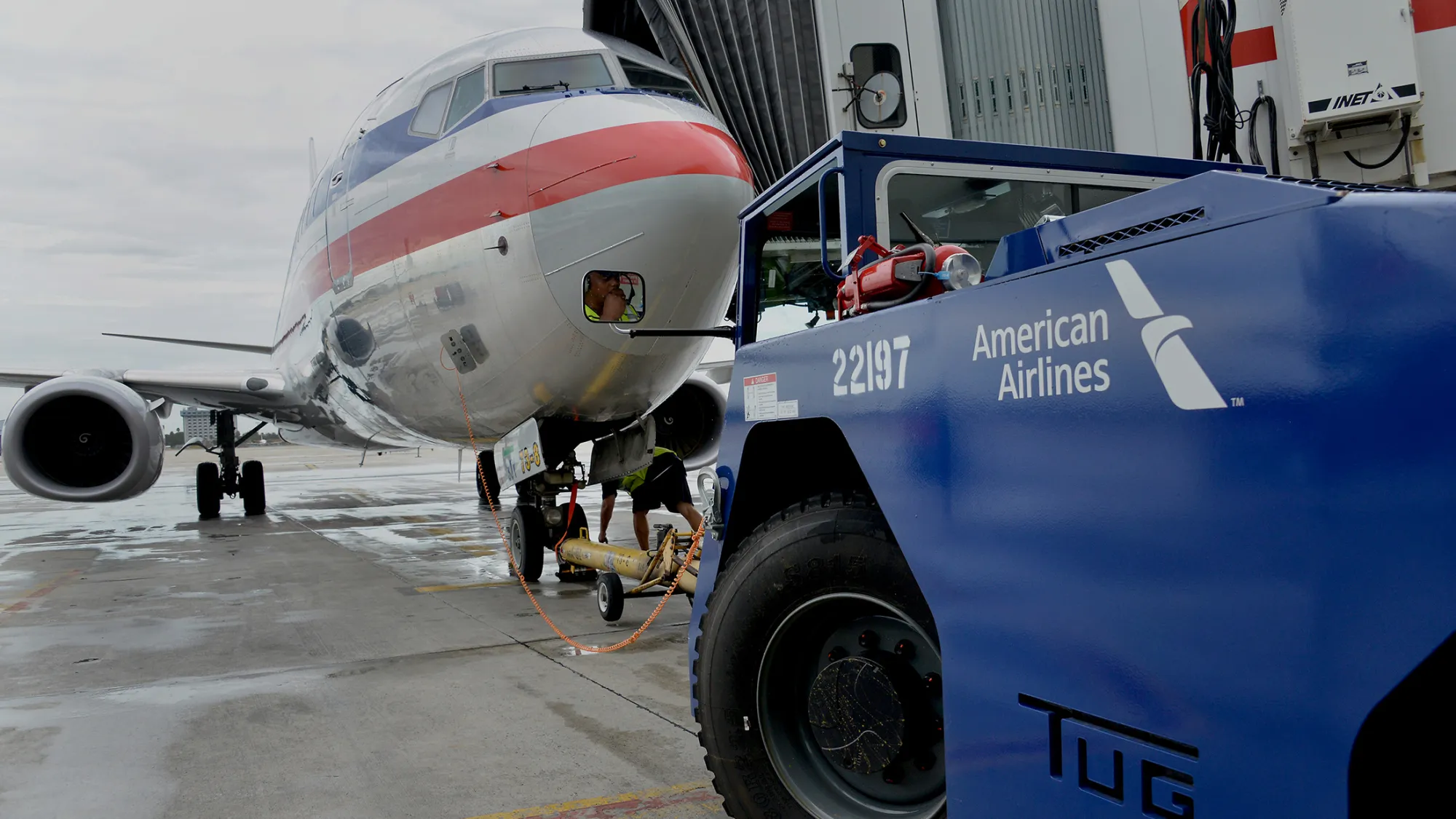 A ground crew member prepares to push back an American Airlines Group Inc. Boeing Co. 737-823 jet at a terminal in Miami International Airport (MIA) in Miami, Florida, U.S., on Tuesday, Sept. 23, 2014. American Airlines Group Inc. is scheduled to release earnings figures on Oct. 17.
