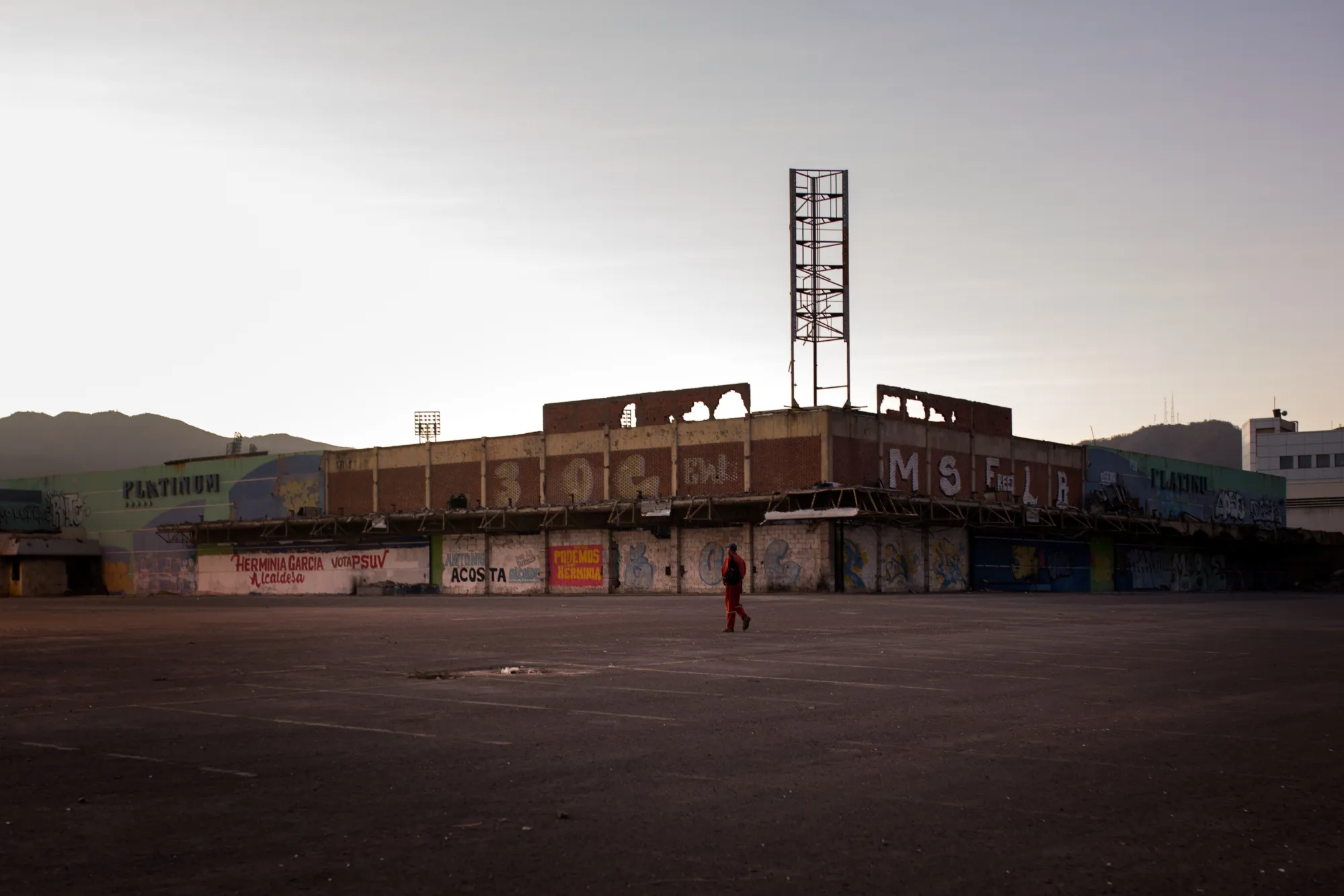 A Petroleos de Venezuela&nbsp;worker heads toward a bus stop to travel to work. Thousands have walked off their jobs as food becomes scarce and money loses value.&nbsp;