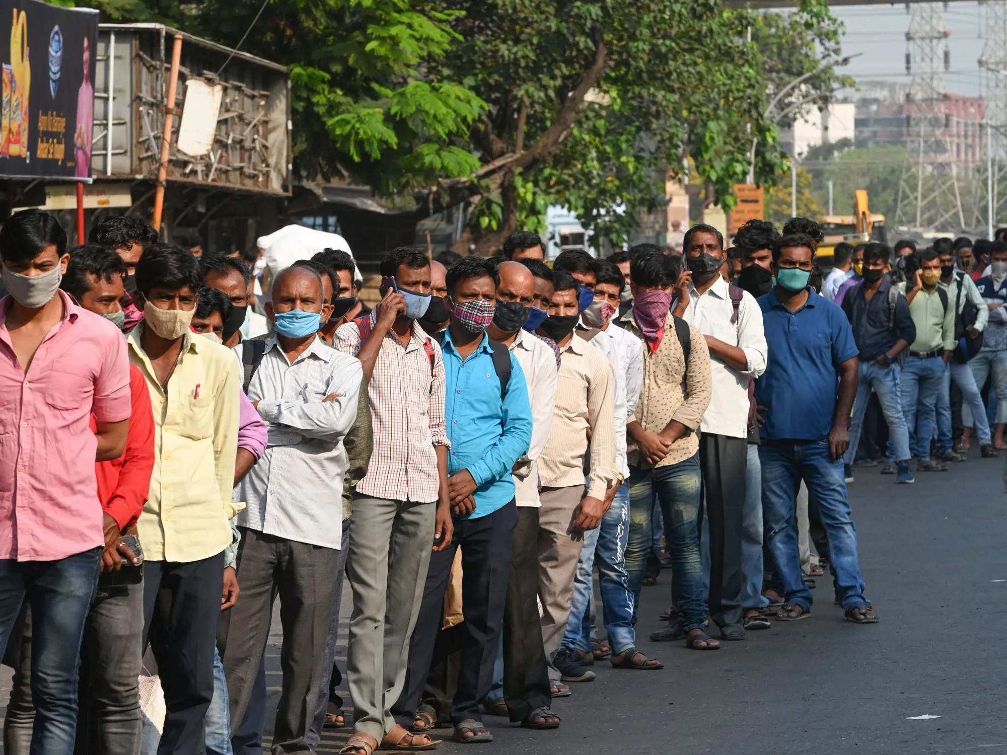 Commuters wait to board buses in Mumbai on March 21.