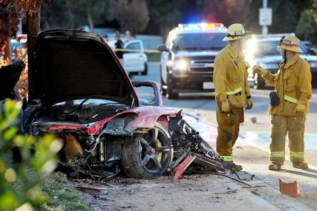 First responders gather evidence near the wreckage of the crash involving Paul Walker, Roger Rodas, and a Porsche Carrera GT on Nov. 30, 2013