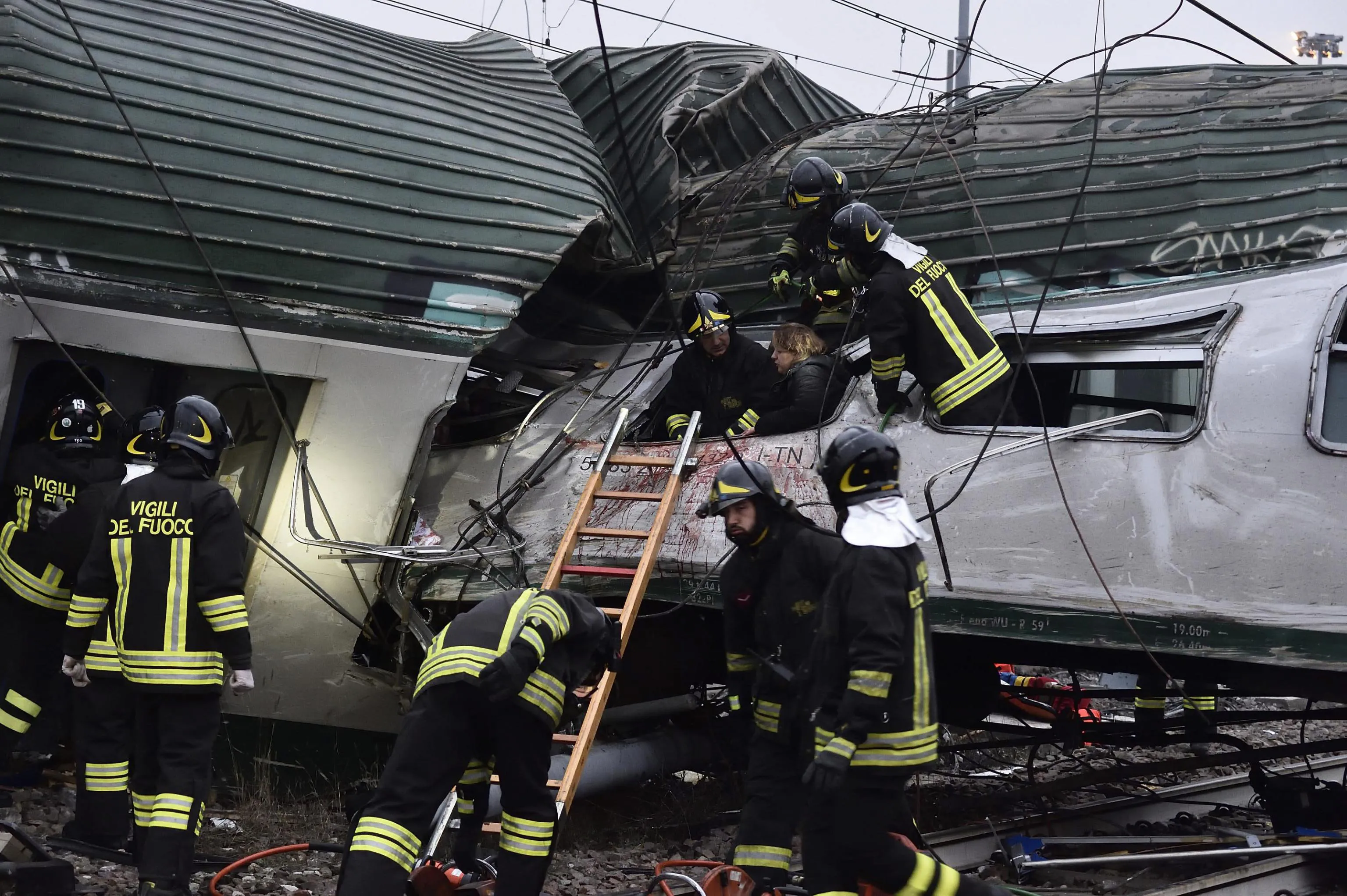 Rescuers help people after a train derailed near Milan, on Jan. 25.&nbsp;