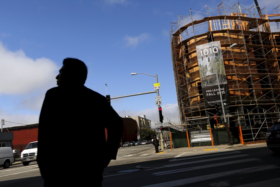 A man stands in front of a construction project in San Francisco, one of the hottest rental markets in the country.
