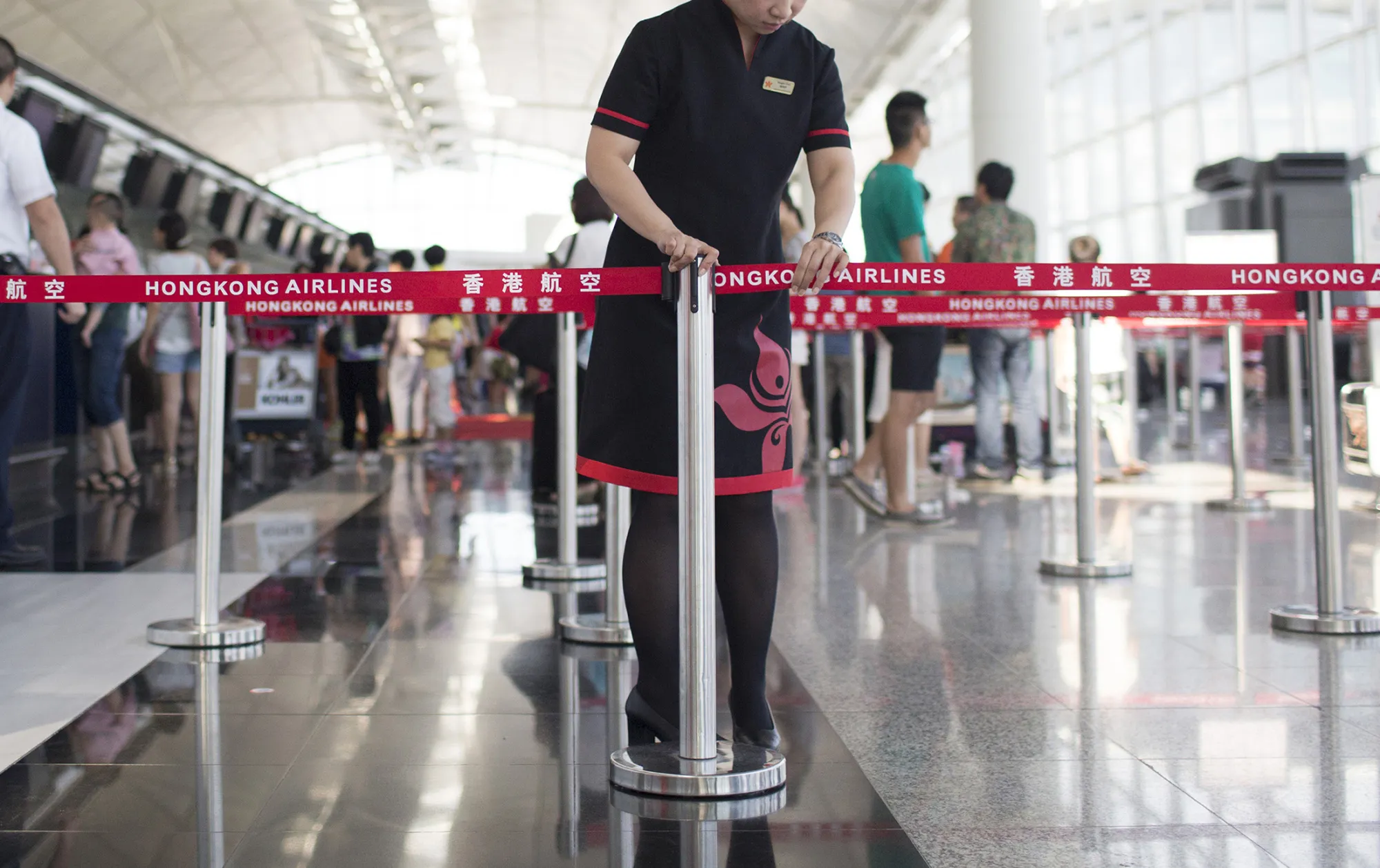 An employee sets up tape near the&nbsp;counter for Hong Kong Airlines, owned by China’s HNA Group, at Hong Kong International Airport.