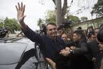 Jair Bolsonaro, presidential candidate for the Social Liberal Party, waves as he leaves a polling station after casting his ballot during the first round of presidential elections in Rio de Janeiro on Oct. 7, 2018.