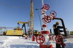 A worker collects a sample of crude oil at a multiple well platform, operated by Rosneft PJSC, in the Samotlor oilfield near Nizhnevartovsk, Russia.