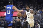 Brooklyn Nets guard Kyrie Irving (11) drives in front of Orlando Magic guard R.J. Hampton (13) during the first half of an NBA basketball game Tuesday, March 15, 2022, in Orlando, Fla. (AP Photo/Phelan M. Ebenhack)